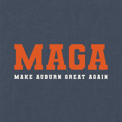 A close-up of a navy blue textured fabric, likely a t-shirt or sweatshirt, featuring a graphic print with the word 'MAGA' in large orange varsity-style block letters and the phrase 'MAKE AUBURN GREAT AGAIN' in smaller white block letters underneath.