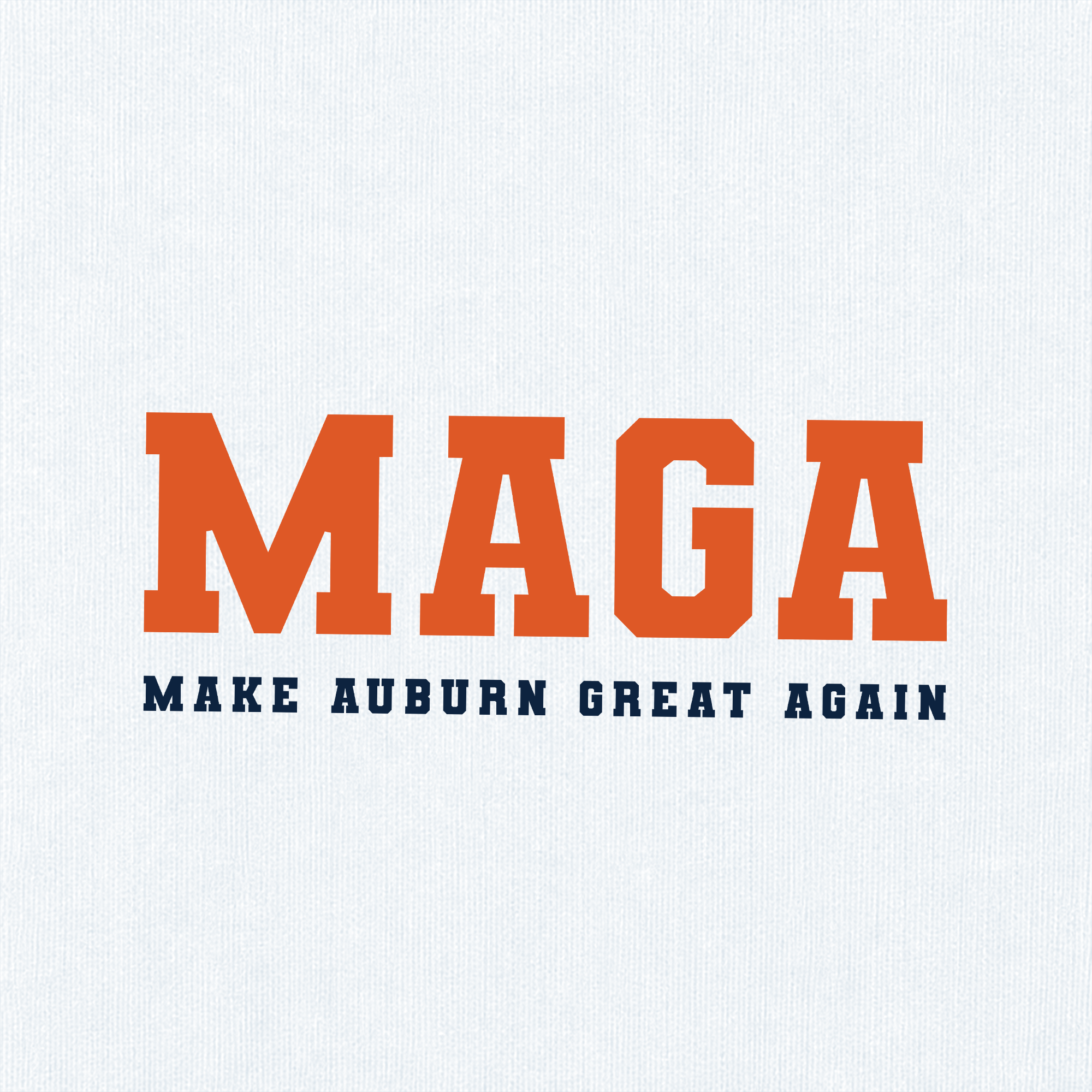 A close-up of a white textured fabric surface with bold orange block letters spelling MAGA and smaller navy text underneath reading MAKE AUBURN GREAT AGAIN.
