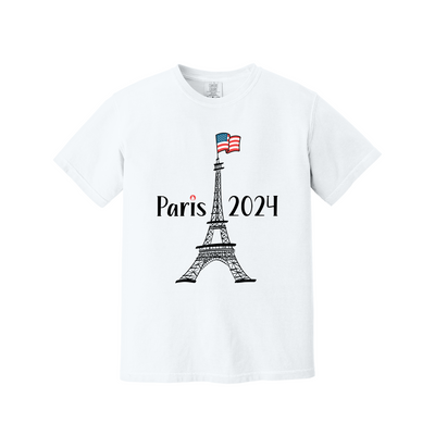 A white short-sleeve crewneck t-shirt featuring a graphic of the Eiffel Tower with an American flag on top and the text 'Paris 2024' printed in black.